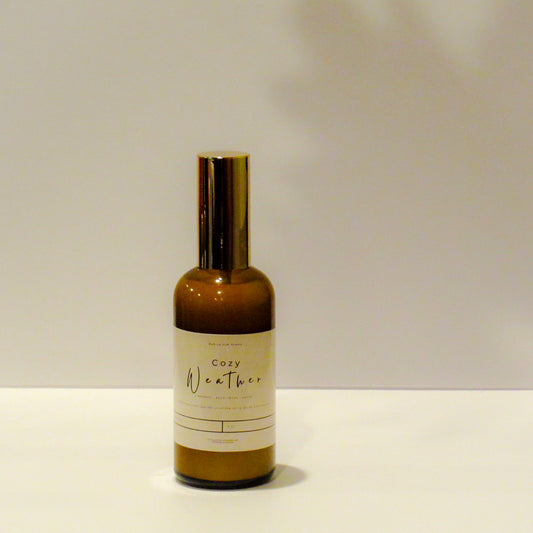 Brown bottle labeled 'Cozy Weather' on a white surface with a light gray background