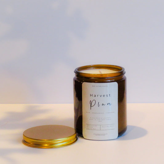 Candle jar labeled 'Harvest Plan' on a neutral background