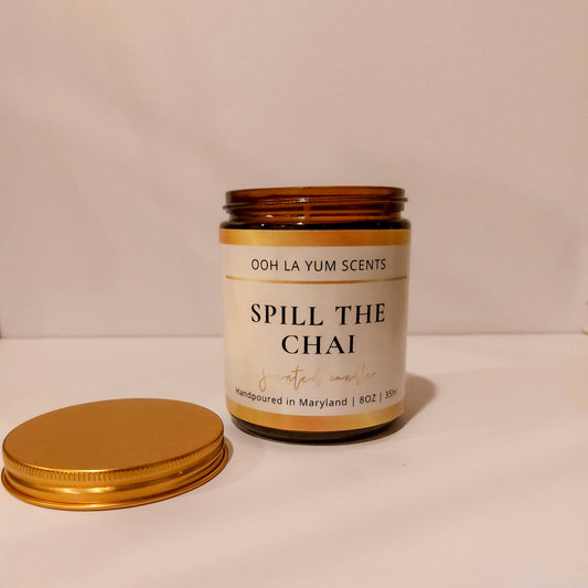 Candle jar labeled 'Spill the Chai' by Ooh La Yum Scents on a beige background