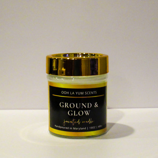 Candle jar labeled 'Ground & Glow' by Ooh La Yum Scents on a white background
