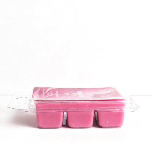 Pink wax melts in a clear plastic container on a white background