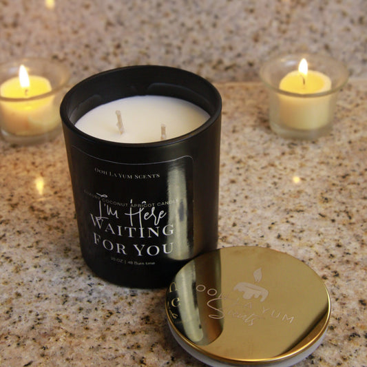 Black candle with 'I'm Here Waiting For You' text on a granite surface with two smaller candles.